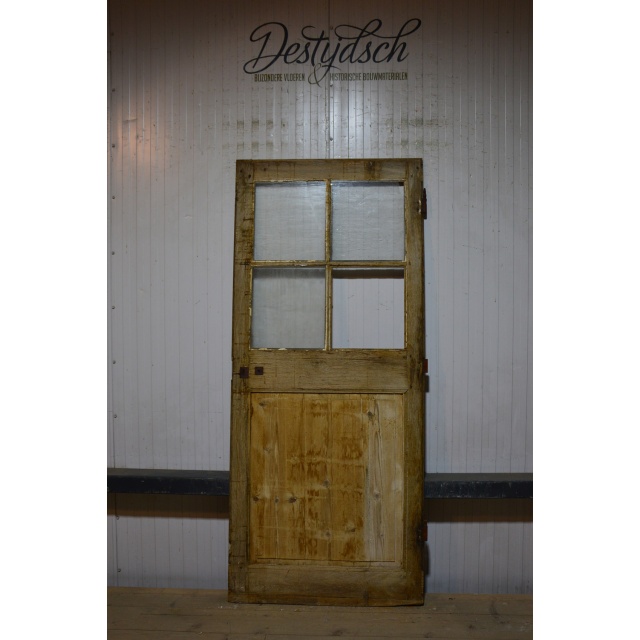 Oude geloogde deur met glas       